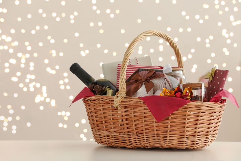 Cesta de Navidad con diferentes productos de alimentación y botella de vino